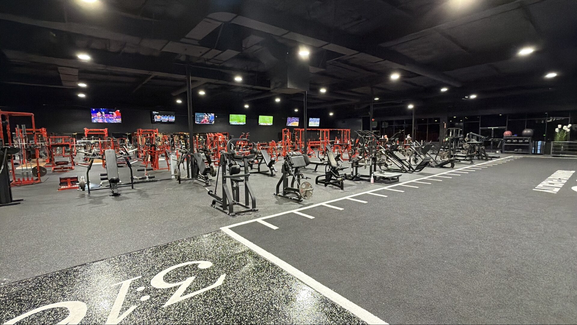 Strength floor at 3:16 Training Facility — red racks and machines